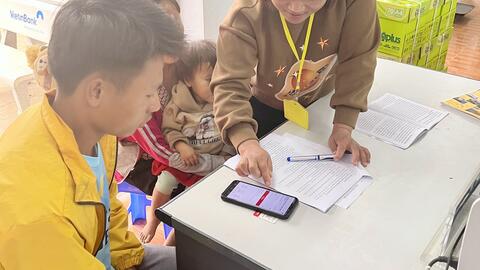 Công chức bộ phận Tiếp nhận và Trả kết quả UBND xã Huổi Luông hướng dẫn người dân nộp hồ sơ trực tuyến, giải quyết thủ tục đăng ký khai sinh